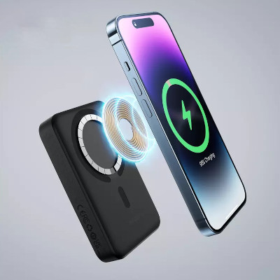 Ilustratie cu atasarea magnetica a acumulatorului Baseus Magnetic Mini Wireless Fast Charger, fiind tinut in dreptul spatelui unui iPhone 14 Pro